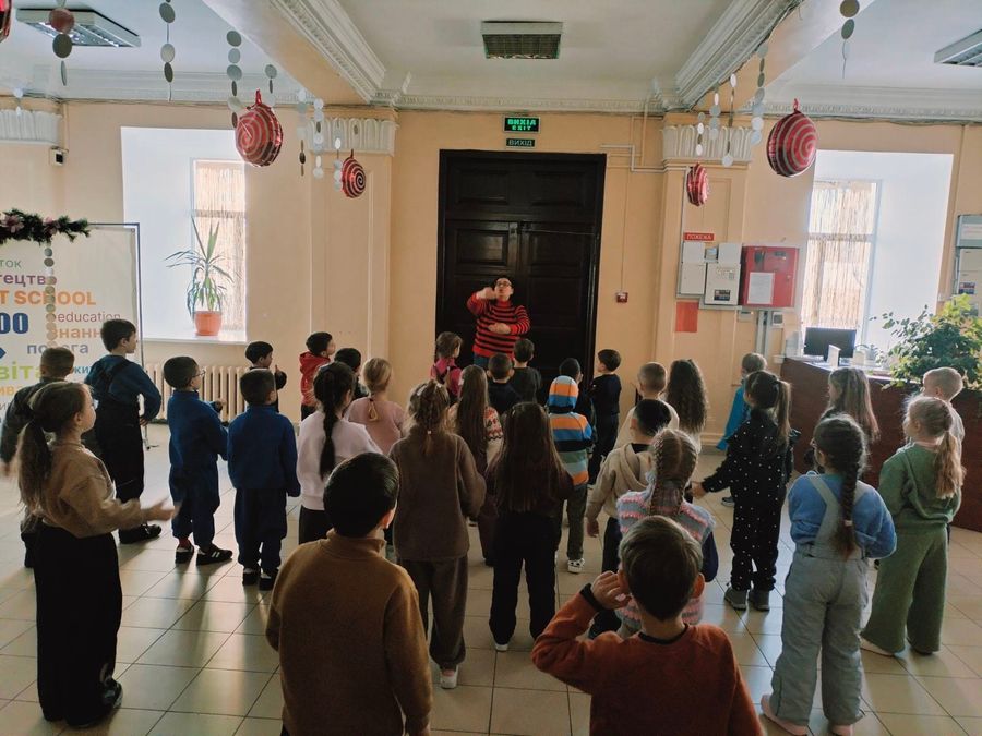 Діти стоять у великому колі в холі ліцею під час рухливої перерви