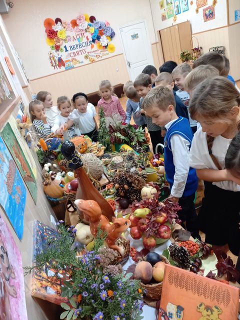 Клас разом розглядає осінню виставку у школі